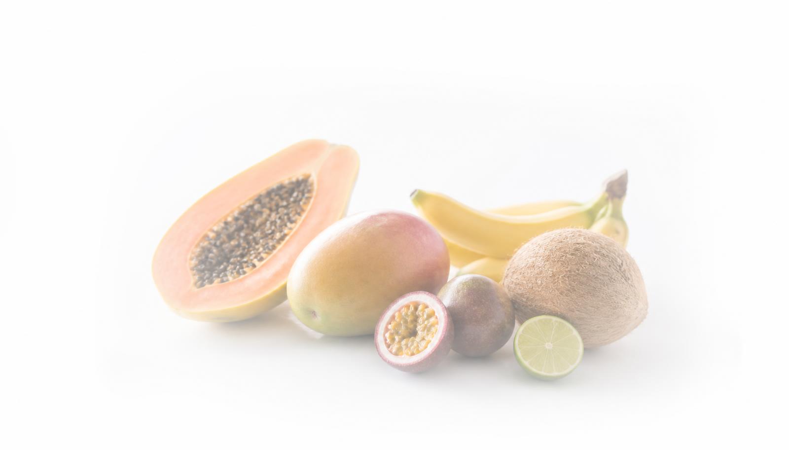 Whole organic tropical fruits on a bright white background